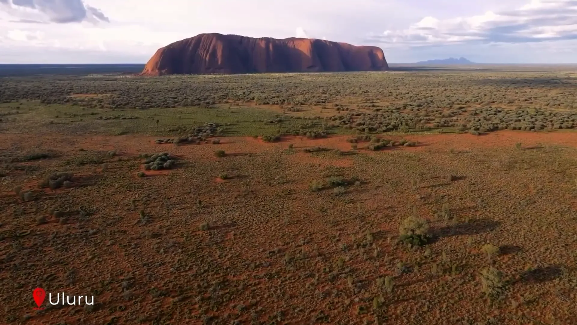 Uluru glowing red under sunset light
