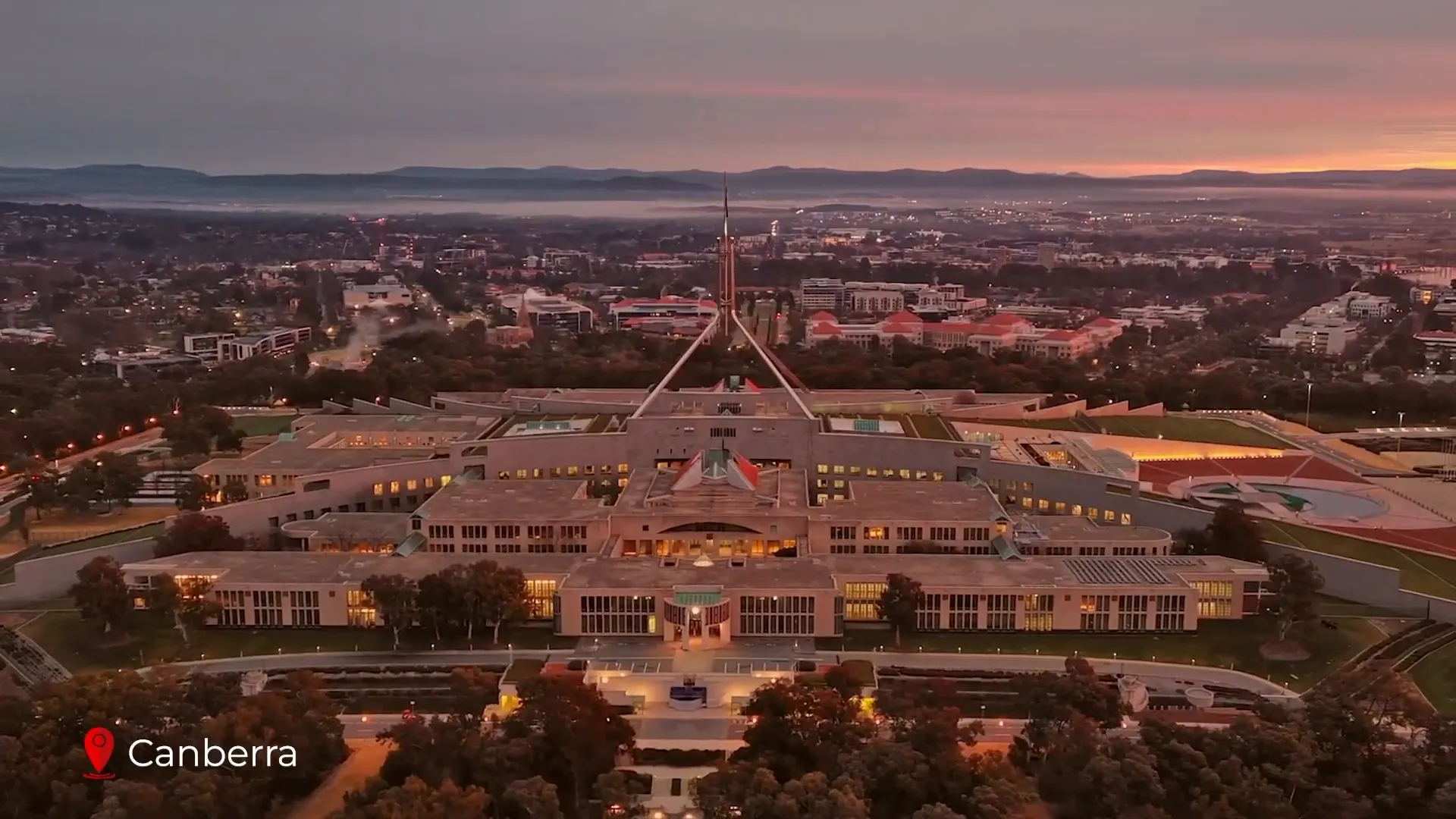 Australian Parliament House with flag and lawns