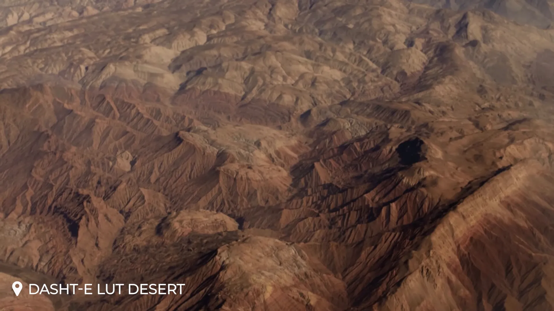 Panoramic view of yardangs and desert formations in the Lut Desert at sunset