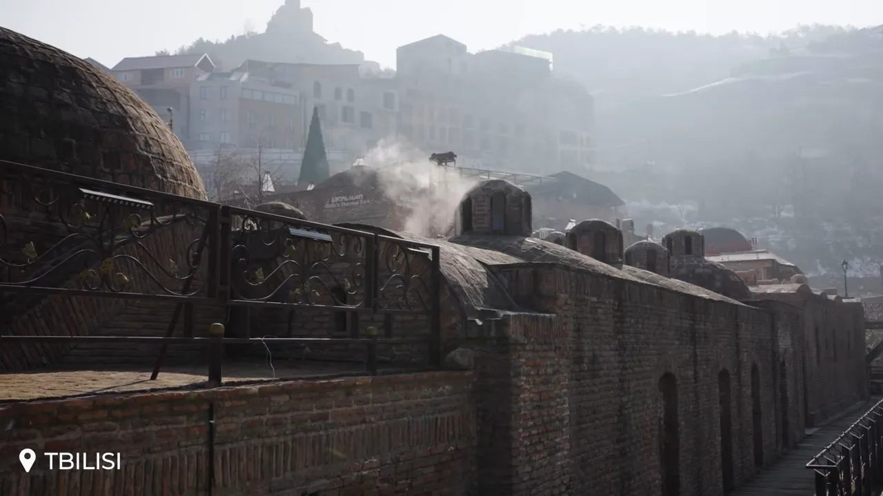 Close view of Abanotubani sulfur-bath domes with visible steam rising in Tbilisi
