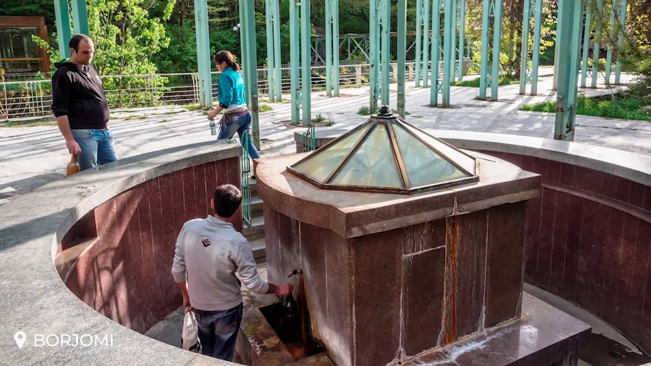 People filling bottles at the Borjomi mineral spring fountain