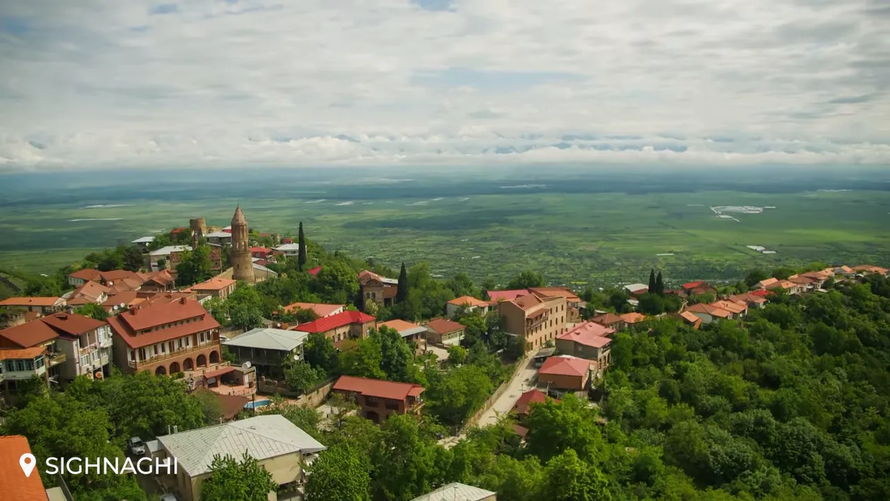 Aerial overlook of Signagi with a central church tower and the sweeping Alazani Valley