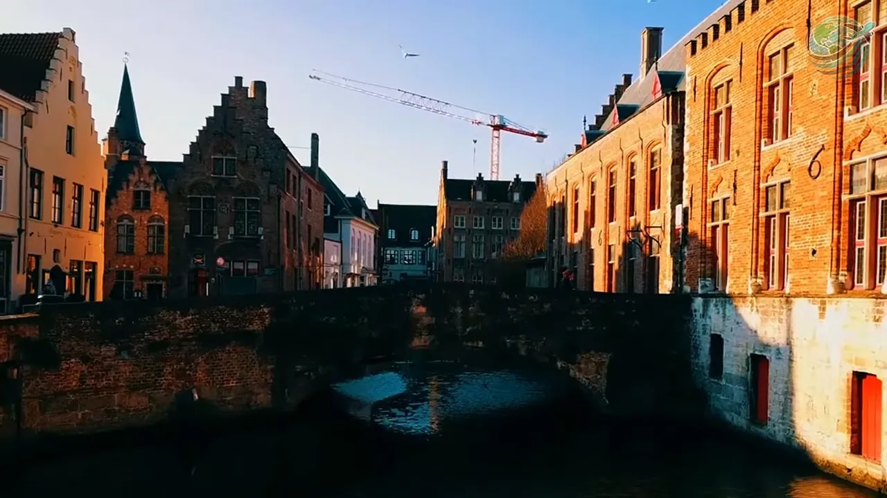 Canal beneath a stone bridge lined with historic brick houses