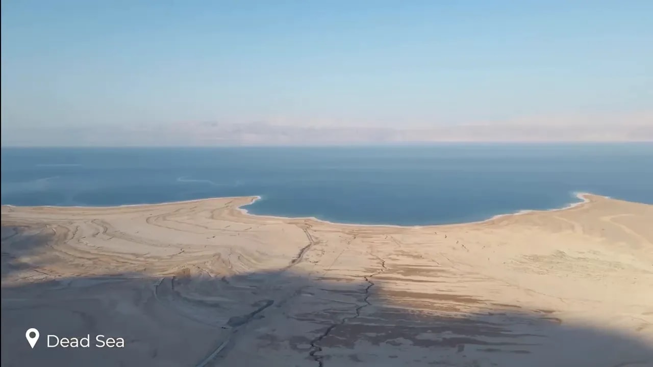 Pale salt formations and blue water along the Dead Sea shoreline