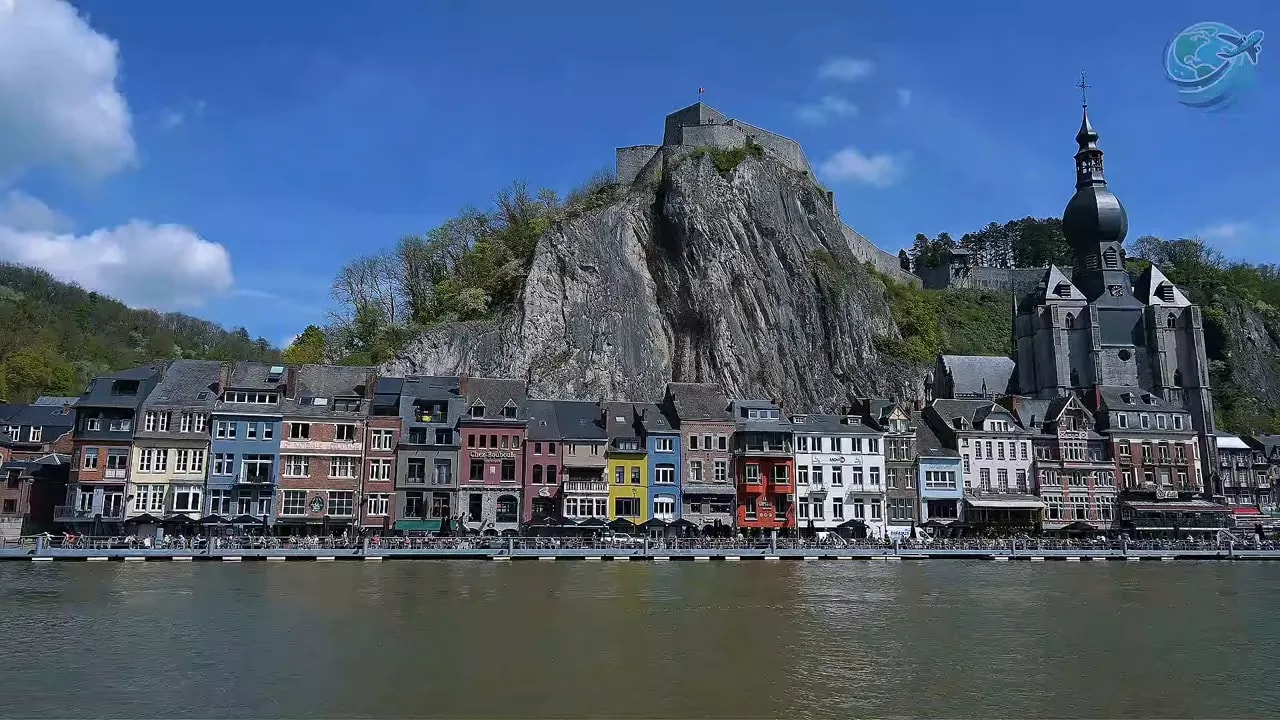 Dinant riverside with colorful houses church tower and steep limestone cliffs
