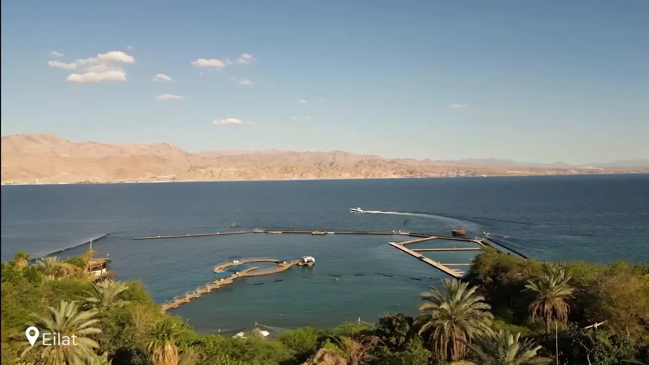 Wide view of Eilat bay with blue Red Sea water and desert mountains