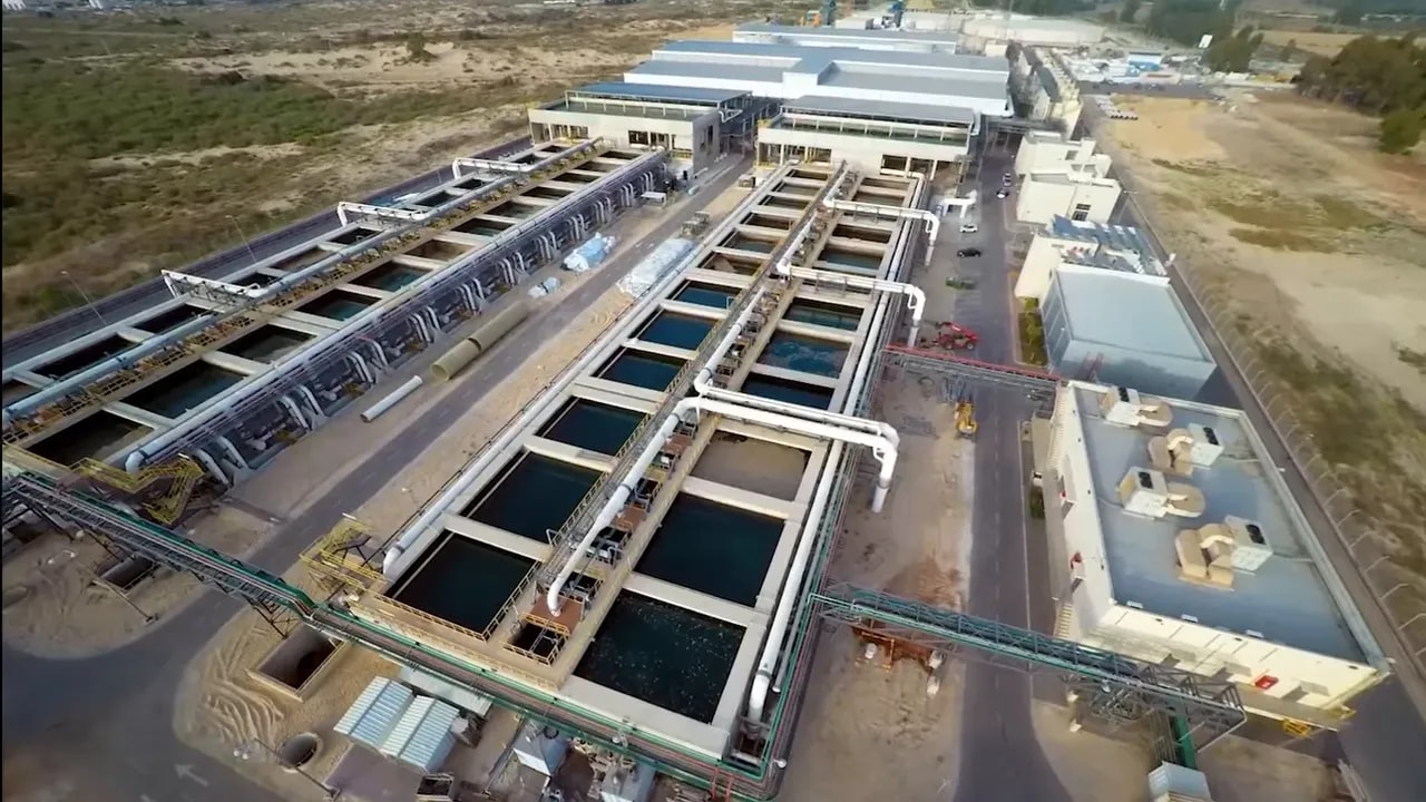 Aerial view of a large desalination plant with water treatment basins