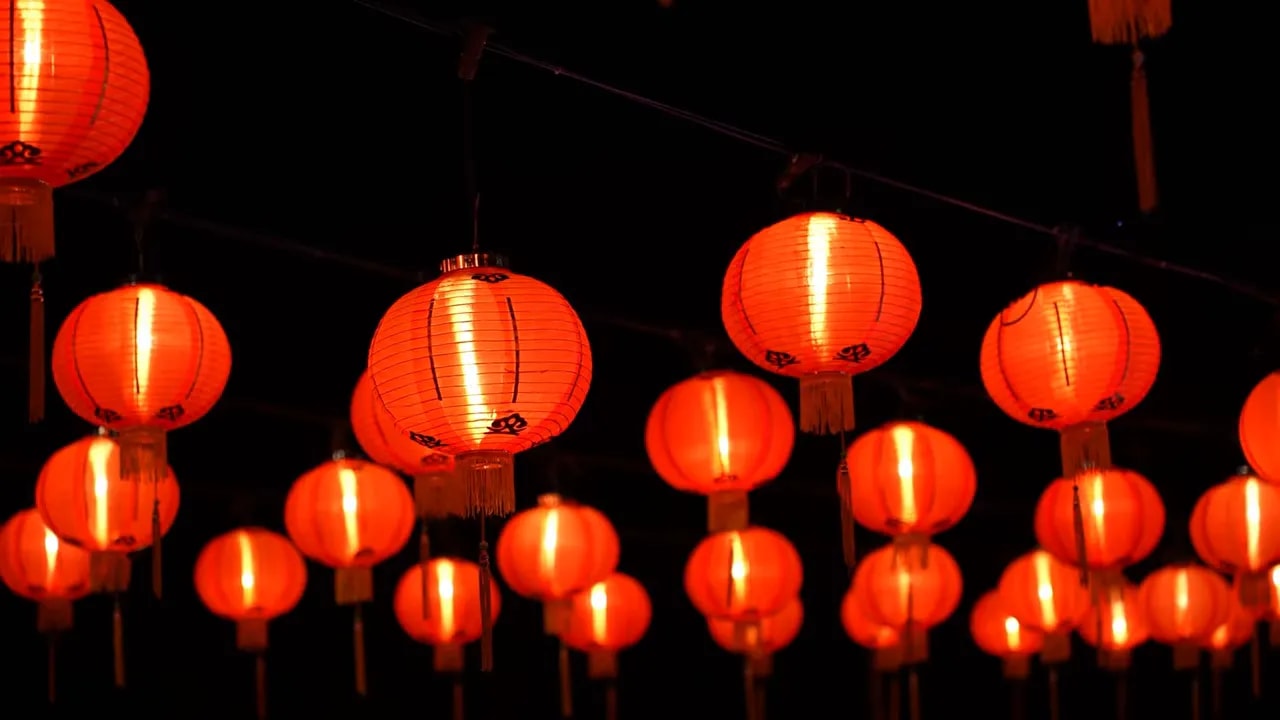 Rows of glowing red lanterns hanging above a street in Jiufen