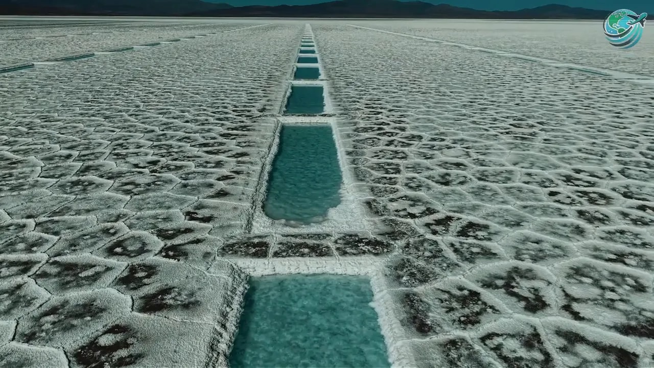 Long turquoise water channels crossing white patterned salt flats