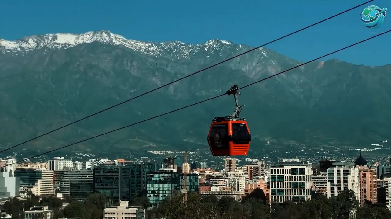 Red cable car above Salta city with green mountains behind it