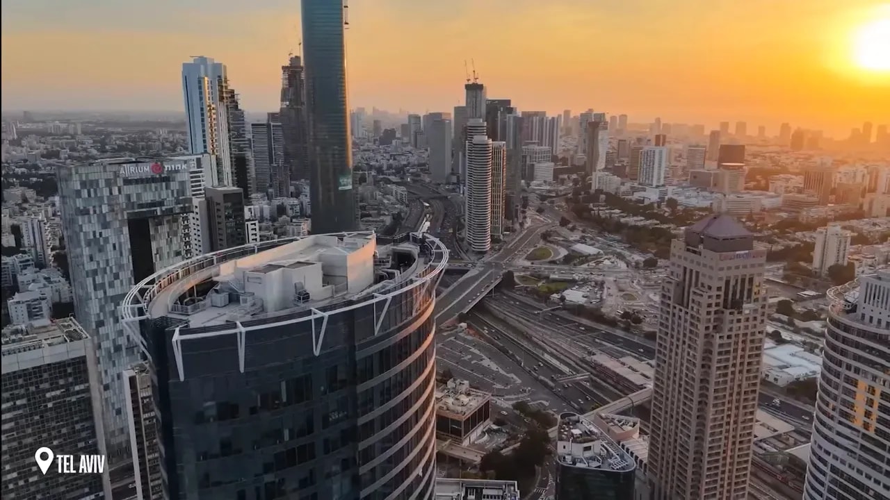 Tel Aviv high-rise skyline at sunset with the sun above the city