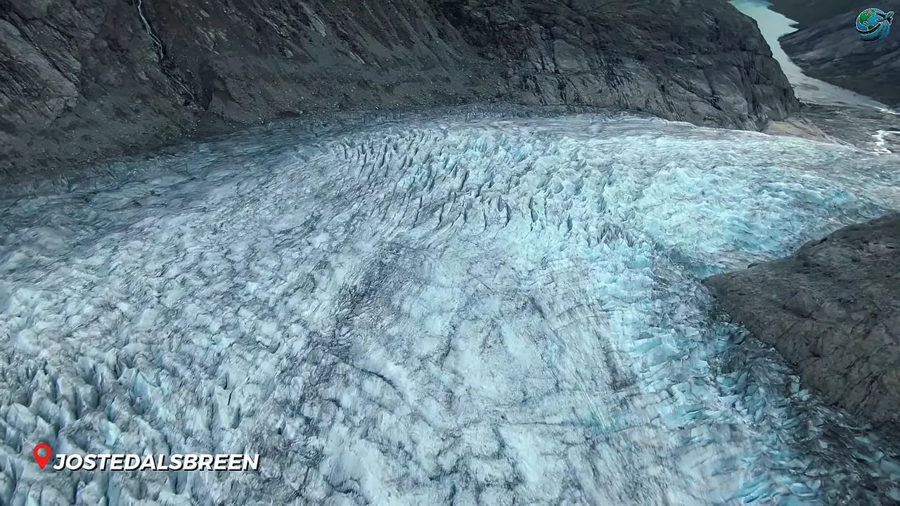 Wide cracked glacier flowing between dark mountains