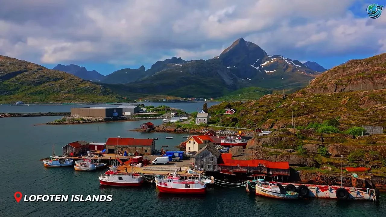 Red fishing boats and cabins beneath Lofoten mountains